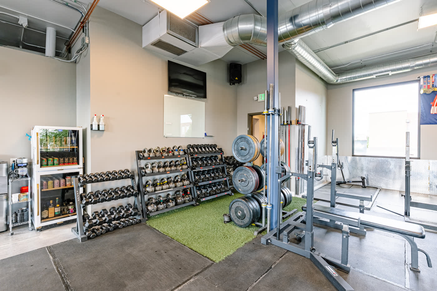 Dumbbell racks and turf lane at The Gym