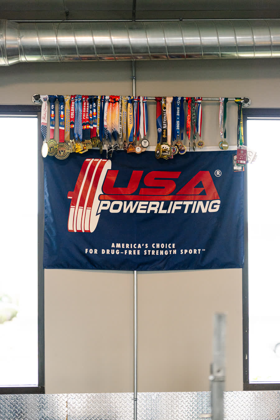USA Powerlifting banner and competition medals at The Gym